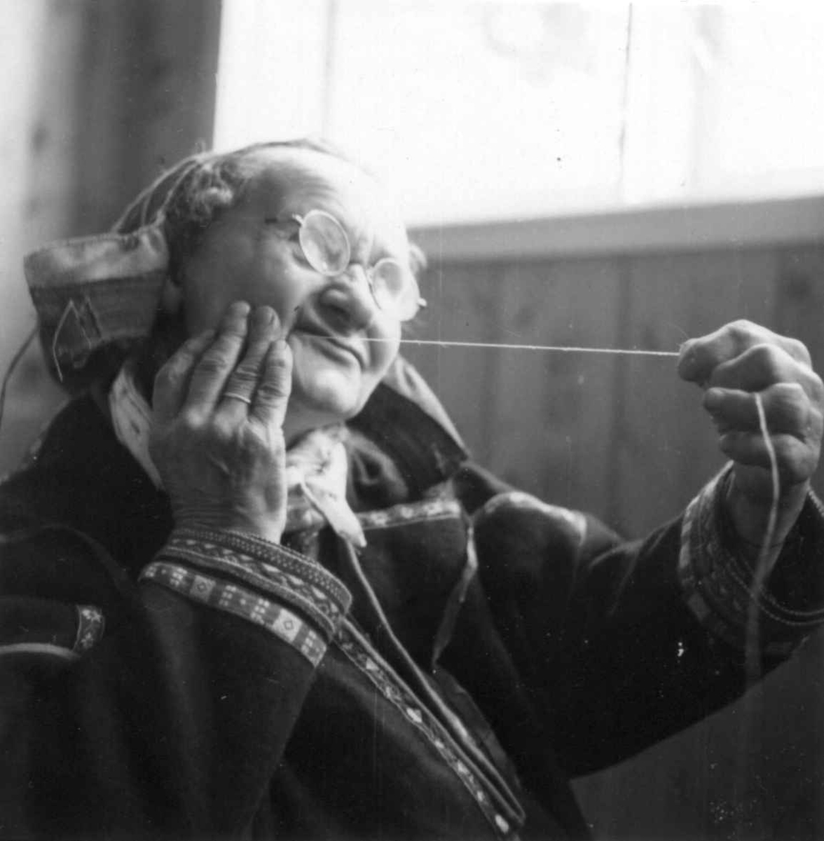 Inger Marie Nilsd. Turi Pulk demonstrerer tvinning av senetråd. Karasjok 1951.