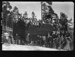 Menn med deltagernummer og tilskuere på en tribune. Holmenko