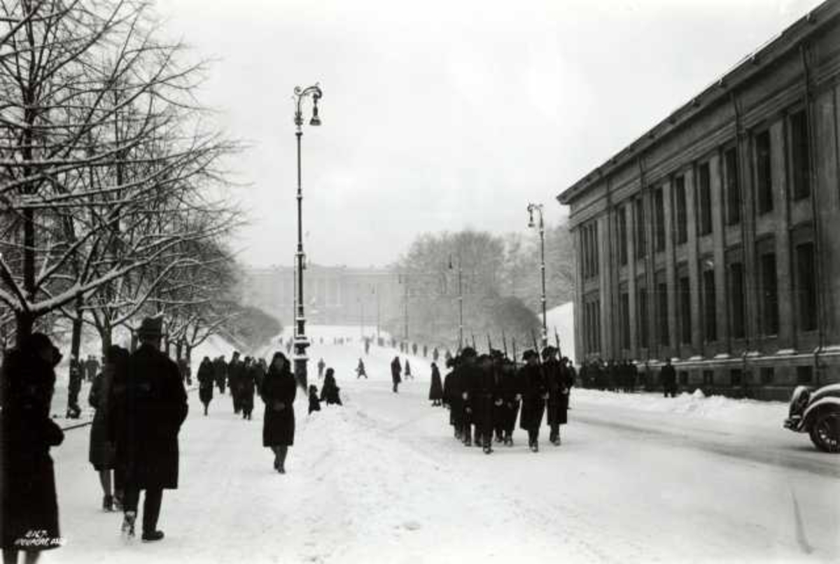 Karl Johan, Oslo 1930. Vinterbilde av  mennesker på Karl Johan, sett mot Slottet og med Universitetet på høyre side. Fotgjengere.