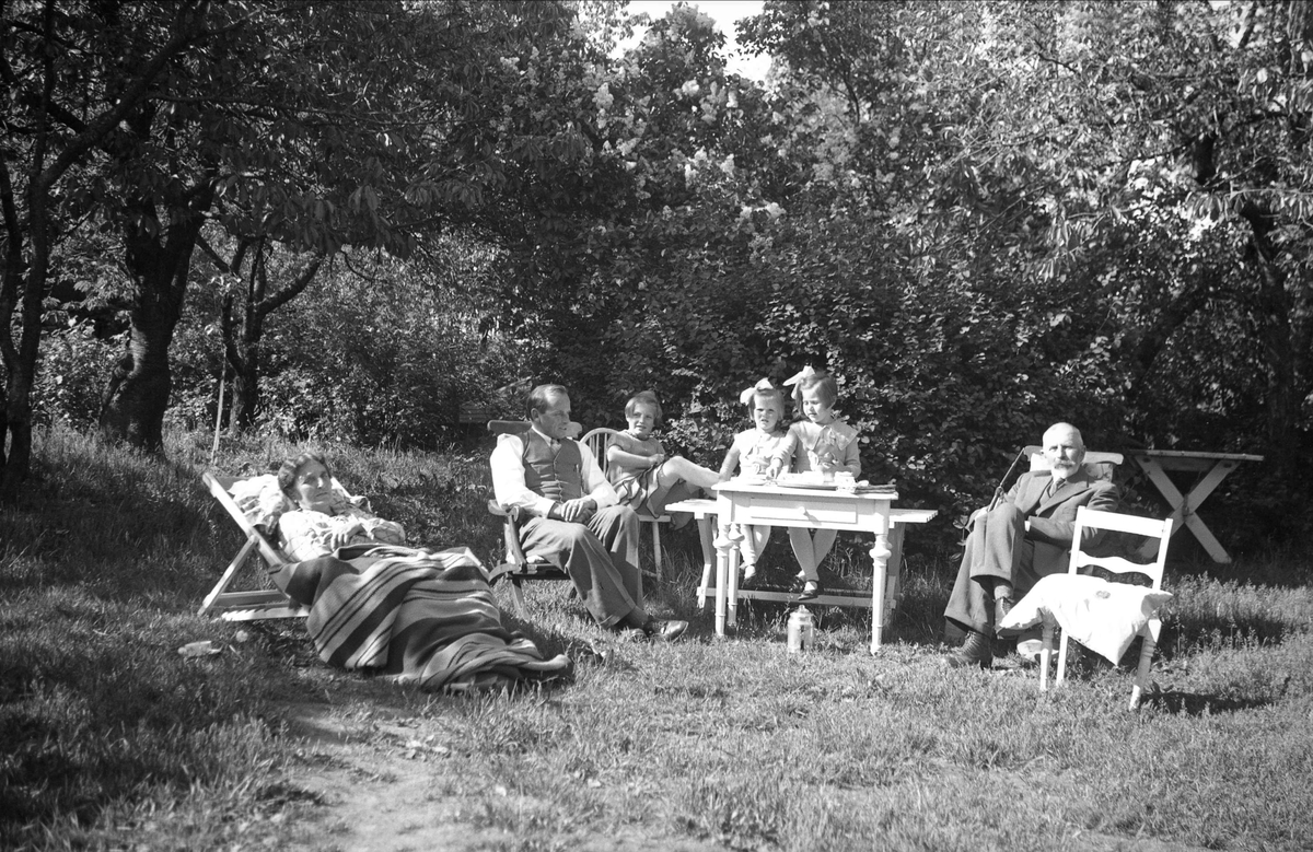 Familen Arentz med farmor og farfar i en hage på Nøtterøy. Fotografert 1935.