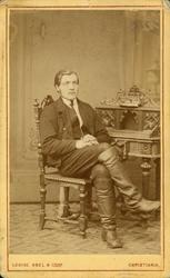 Visittkort. Portrett av mann sittende på stol.