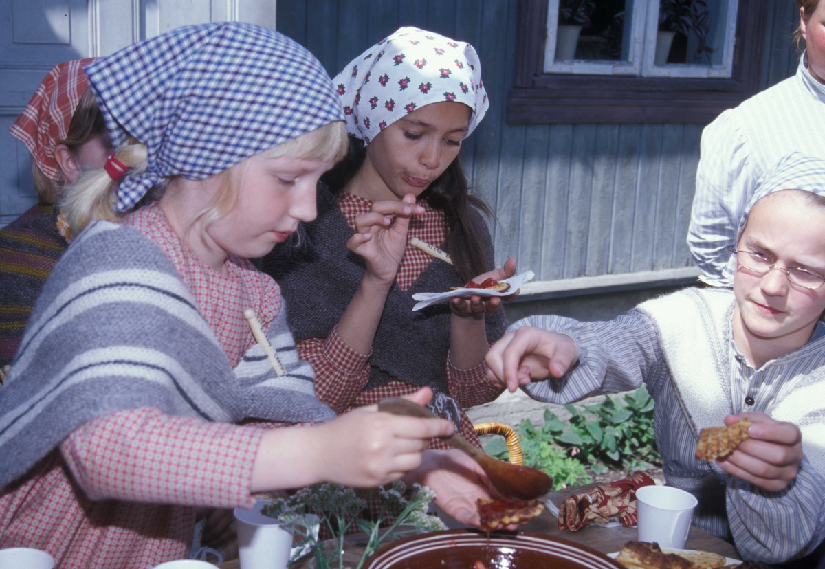 Levendegjøring på museum.
Fra Ferieskolen august 2004.Barna utkledd  i drakter er skjønt enige.
"Vafler med jordbær er godt "
Norsk Folkemuseum, Bygdøy.