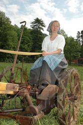 Fra slåttonna i juni 2005. Vert i drakt sitter på slåmaskin.