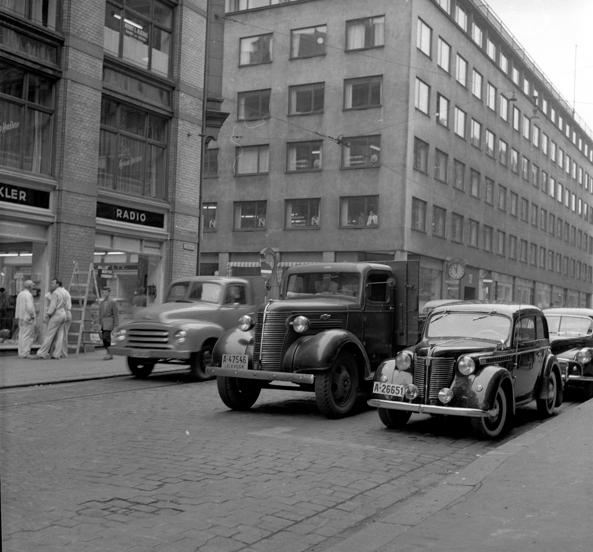 Fra venstre bil av typen Opel Blitz 1952-58, Chevrolet lastebil 1938 og Opel Olympia 1938-39. Trolig Morris Minor bak den.