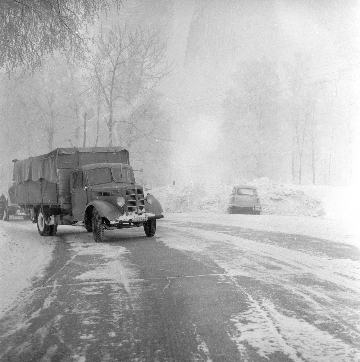 Lastebil av typen Bedford, årsmodell 1946-53, kjører langs Trondheimsveien i snøvær.