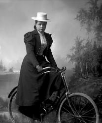 Portrett, kvinne på sykkel, en bicykle. Frk Sæmb.