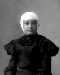 Portrett, kvinne i svart kjole, bandasjert hode.