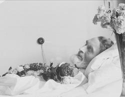 Post mortem-fotografi. Død mann i pyntet seng. Trolig på sy