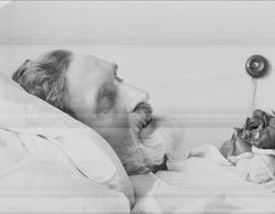 Post mortem-fotografi. Død mann i pyntet seng. Trolig på sy