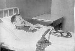 Post mortem-fotografi. Død mann i seng.