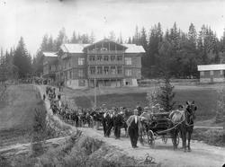 Opptog med hestekjøretøyer på vei foran Konnerudkollen Turis