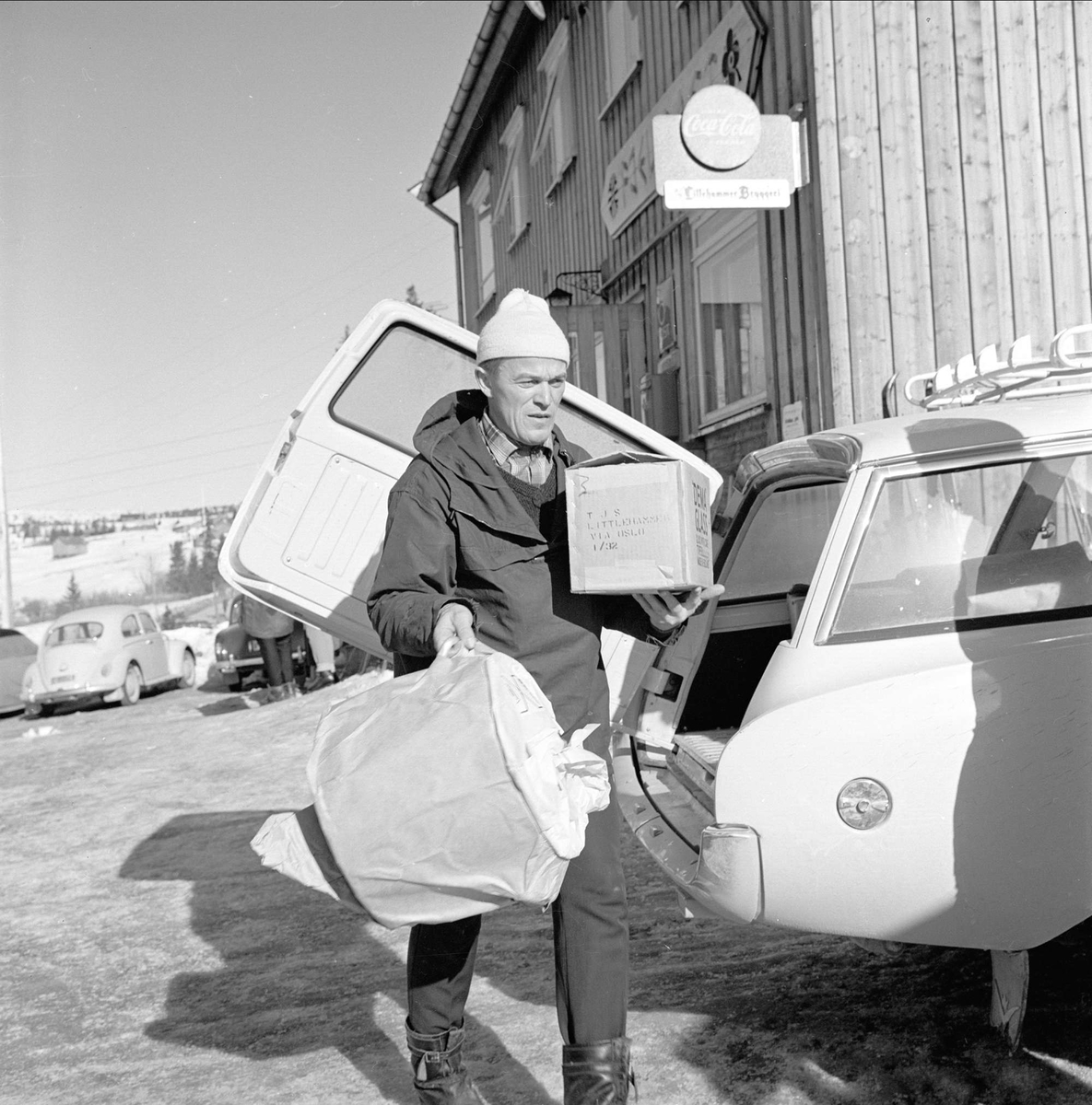 Øyer, Oppland, 25.03.1964. Skiturist, biler og bygning. Ant. ved Pellestova.