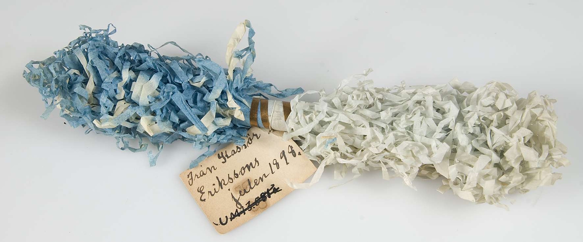Julgranskaramell av blått silkespapper. Handskriven lapp: " Från kassör Erikssons, julen 1898".