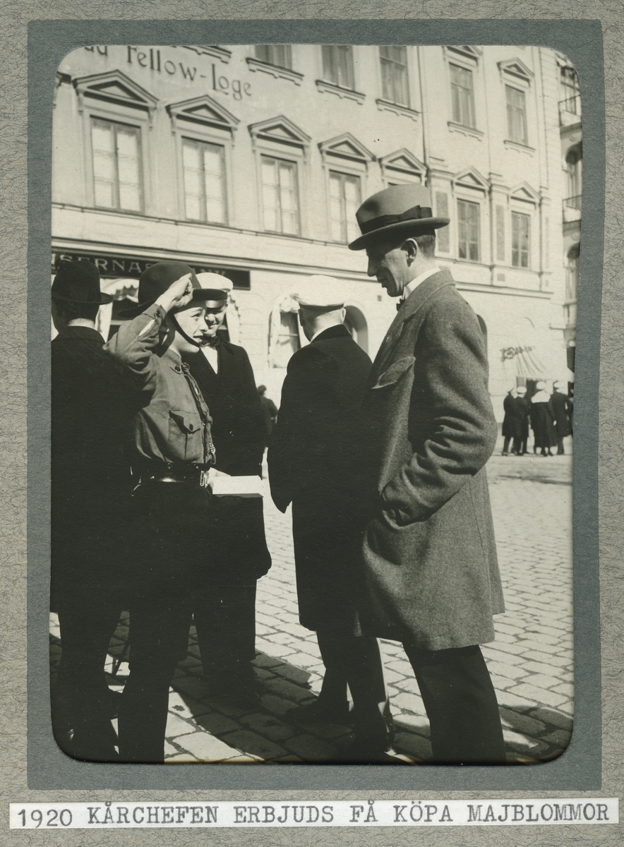 Scout gör honnör mot kårchefen, i bakgrunden män i studenmössor, Nybron, Uppsala 1920