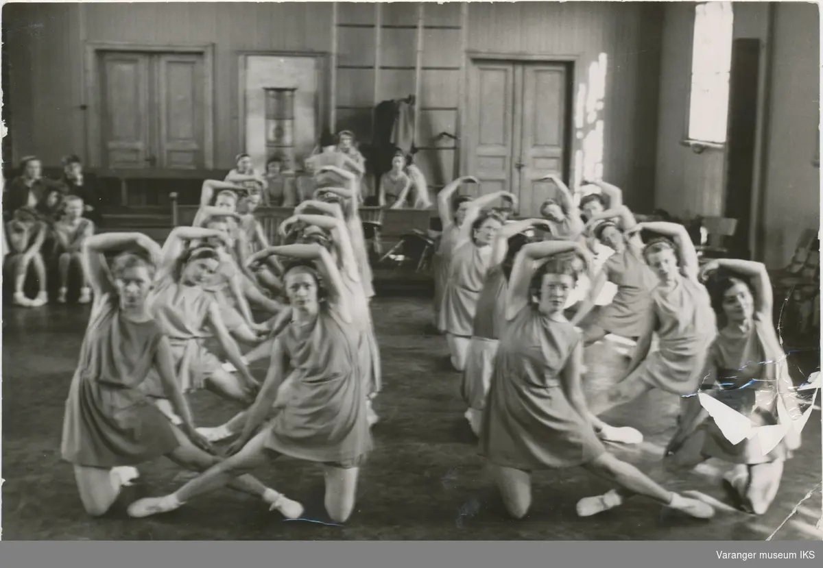 Unge kvinner øver i den gamle gymnastikksalen