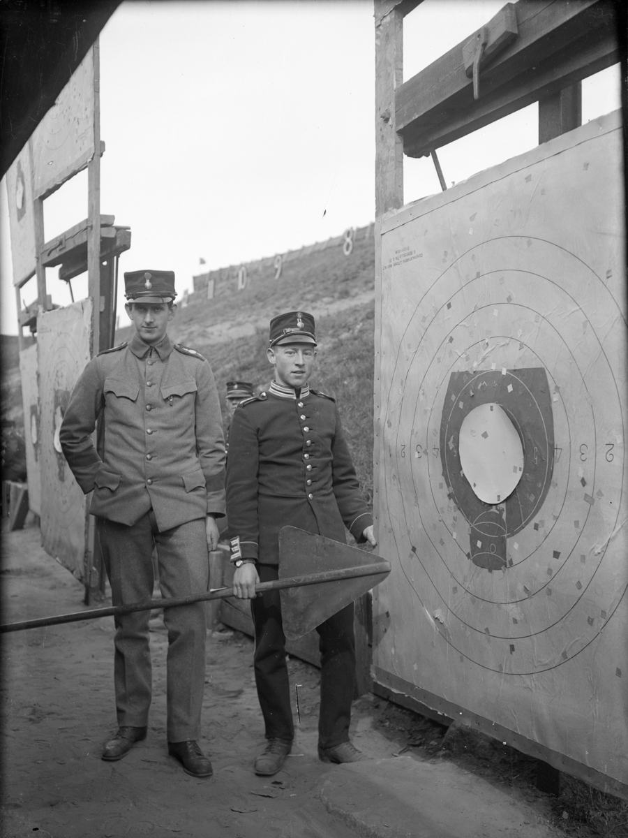 Två armésoldater från I 4 och / eller I 5 regemente står vid en måltavla på ett skjutfält. Mannen till höger är Ernst Axfors.