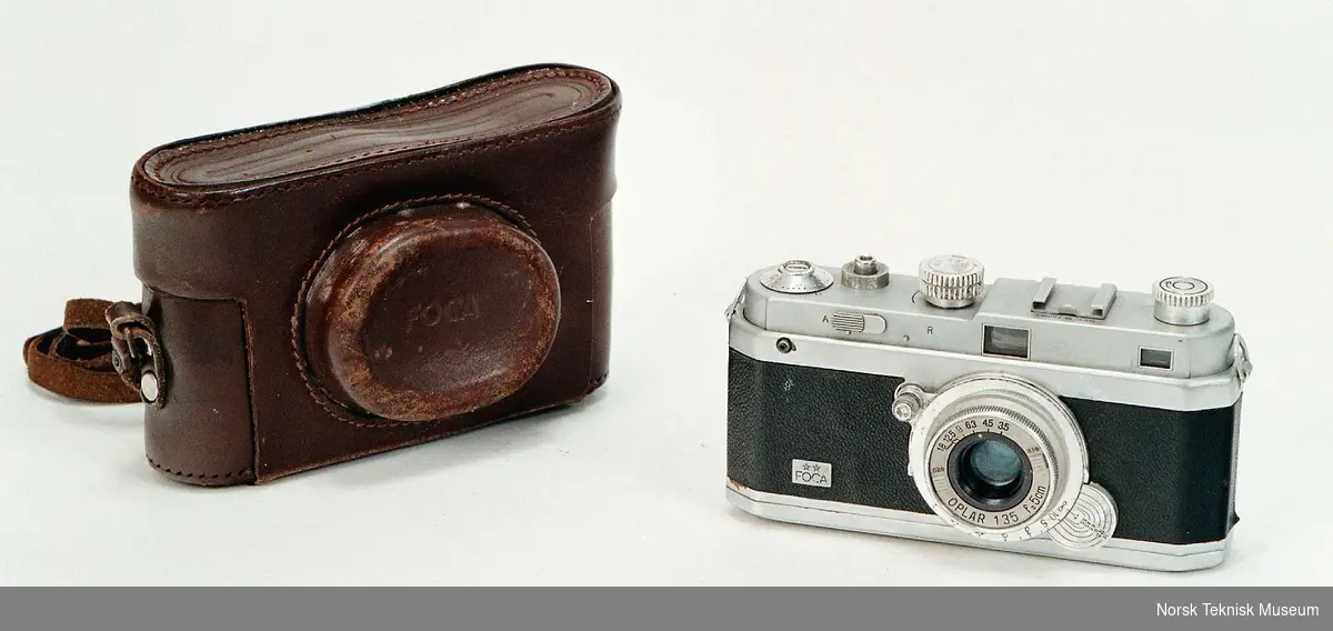 Fransk produsert 35mm kamera
Objektiv: Oplar 1:3,5  f=5cm
No. 49971 B
Gardinlukker
Veske 