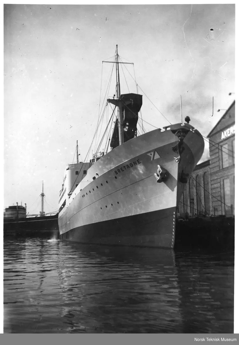 Eksteriør, passasjer- og lastebåten M/S Bretagne, B/N 470 (solgt og omdøpt til M/S Massalia i 1958) til kai utenfor Akers Mek. Verksted i 1937. Skipet ble levert av Akers Mek. Verksted i 1937 til Fred. Olsen & Co, Oslo.