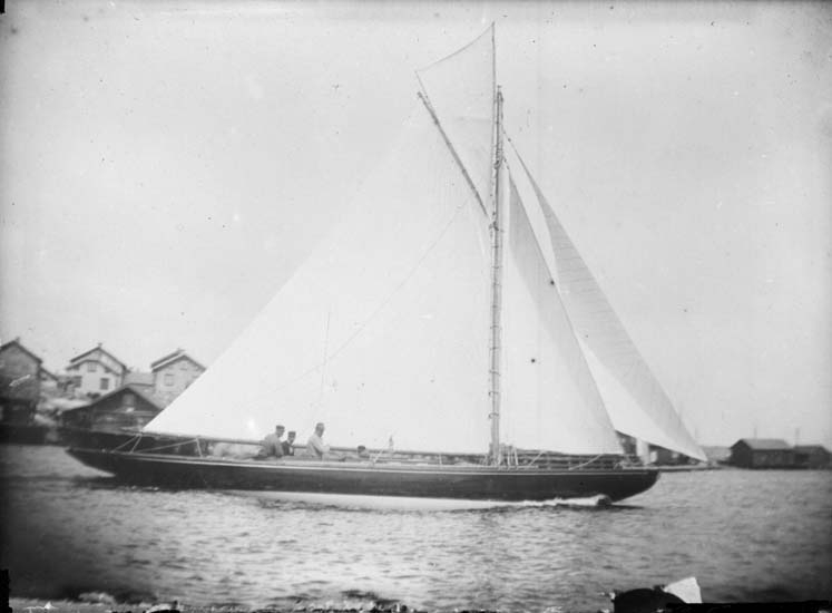 Enligt text som medföljde bilden: "Vid Tången. En norsk modern lustjakt för fulla segel, "Brand" från Fredrikshald 9/7 1899."