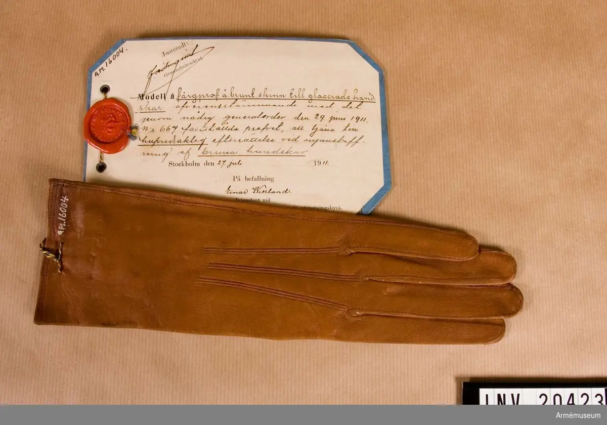 Grupp C I.
Färgprov m/1911, brunt skinn,  H-handske, till glacerade handskar, att tjäna till huvudsaklig efterrättelse vid  anskaffning av bruna handskar.
Färgprov m/1911, handskar, Hallands reg.