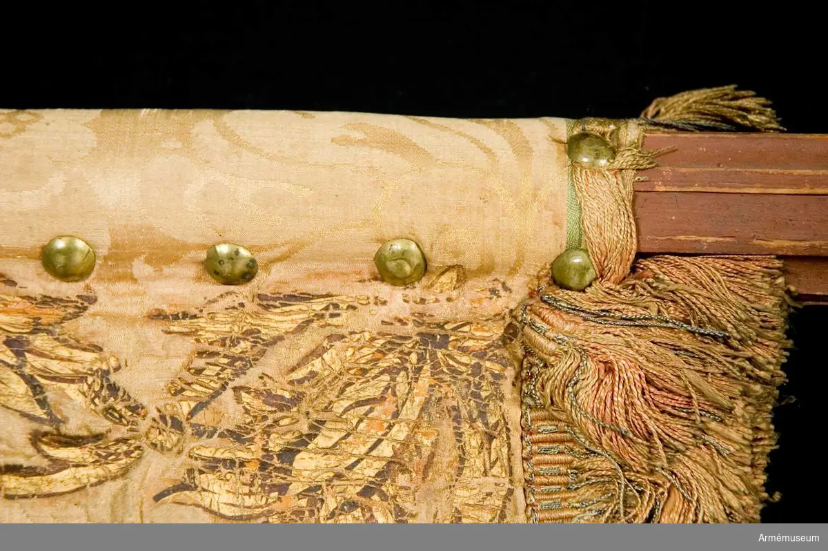 Duk: Tillverkad av dubbel, rosa sidendamast (mycket blekt). Duken fäst med tre rader tennlikor utan band.

Dekor: Målad på inre sidan en gyllene, rödskuggad grip (Östergötlands vapen); längs kanten bård av stiliserade bladverk, kronor och korsade palmkvistar i rödskuggat guld; på yttre sidan Karl XI:s namnchiffer, dubbelt C under sluten krona, prydda med pärlor i silver och stenar i rött och grönt; bården liknar innersidans, allt i rödskuggat guld. Kantbård av silke och guldtråd i laxrosa.

Stång: Tillverkad av trä, kannelerad, rödmålad; löpande bärring; grepp; holk och spets av förgyllt järn(?), spetsbladet med dubbelt C under öppen krona.