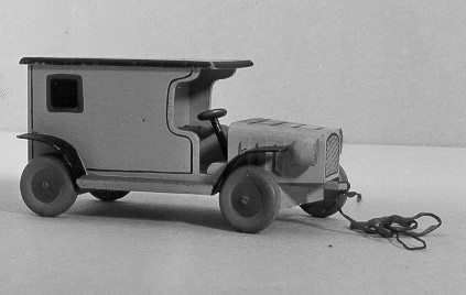 Leksaksbil form av postskåpbil, gul med svart tak,
öppenförarplats och svarta stänkskärmar. Hjulen är grå och röda.