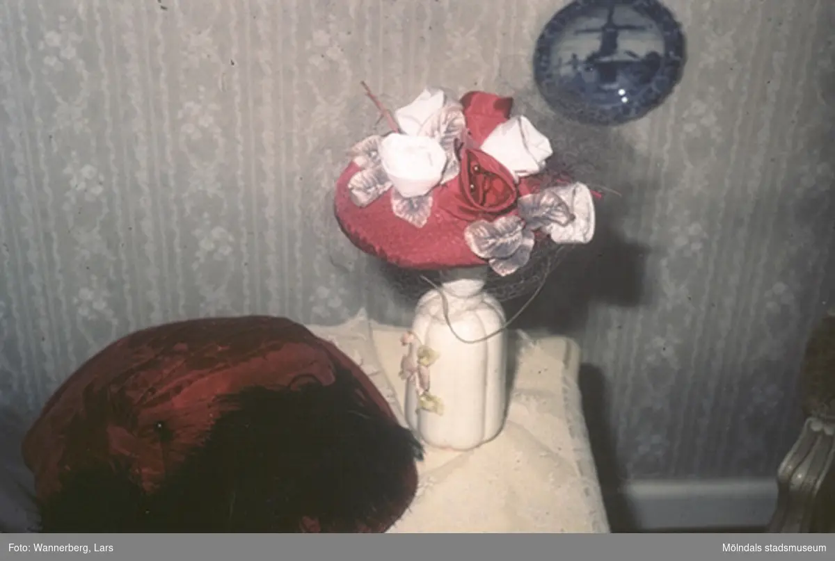 Hatt (invnr. 03339) med signatur "Ingeborg Sweden" i stil med 1990-talsklänning (invnr. 03335_1-3).
Gudmorshatten (invnr. 03338), tillverkad 1911, syns dåligt brevid. Hattarna finns i Mölndals museums samlingar.