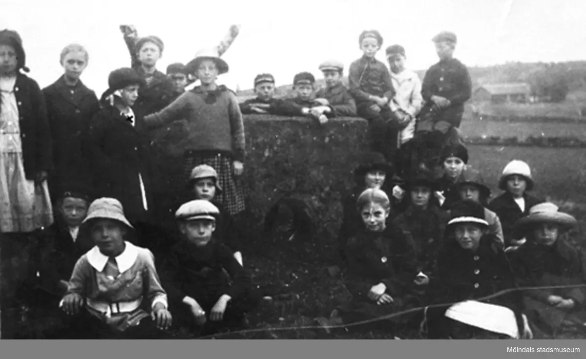 Skolelever från Liveredsskolan i Kållered, år 1921. Barnen är på utflykt till hällkistan "Dvärgahuset" i Dvärred. Tredje barnet stående från vänster, flickan med mörk hatt, är Rosa Krantz (gift Pettersson).