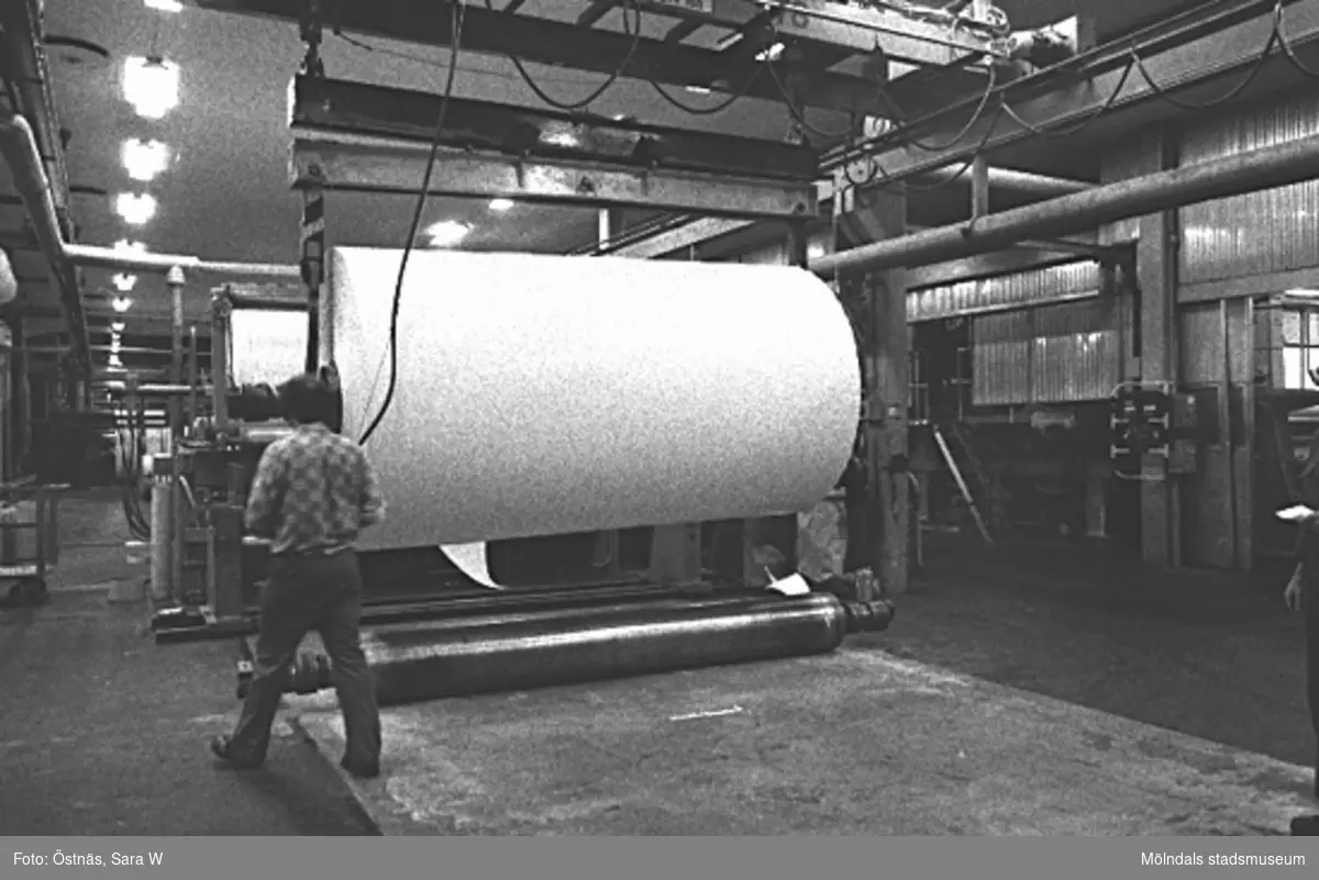 Aarno Aspbäck i arbete med kartongrulle i Byggnad 6, 1980-tal. Bilden ingår i serie från produktion och interiör på pappersindustrin Papyrus.