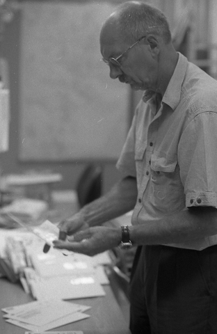 Lantbrevbärare Reinhold Andersson sorterar post inne i
sorteringsdelen på en postanstalt. Tillhör en dokumentation av en
lantbrevbärare i trakten av Valdermarsvik av fotograf Ove Kaneberg.