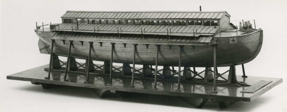 Kravellbyggd modell av sjuktransportfartyget Widar/Vidar.
Modellen står på stapelblock och är stöttad av åtta stöttor på vardera sida. Stapelblocken är fastsatta på en bottenplatta av mahogny försedd med skala.