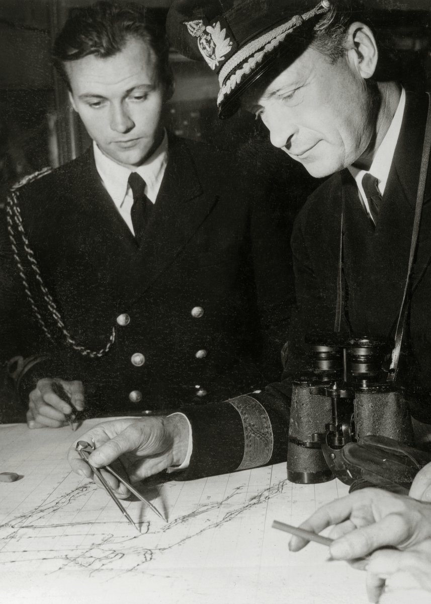 Konteramiral Erik af Klint och adjutanten Lt. Nils Hellström samt okänd 3:dje man plottar kursen ombord på kryssaren Tre Kronor.