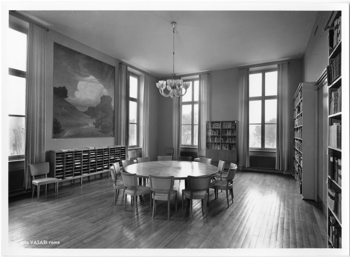 Svenska Institutet i Rom
Interiör. Möblerat rum med runt bord i mitten och bokhyllor utmed tre väggar.