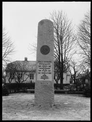 Bauta minnestein for Roald Amundsen, i bakgrunnen fødestedet