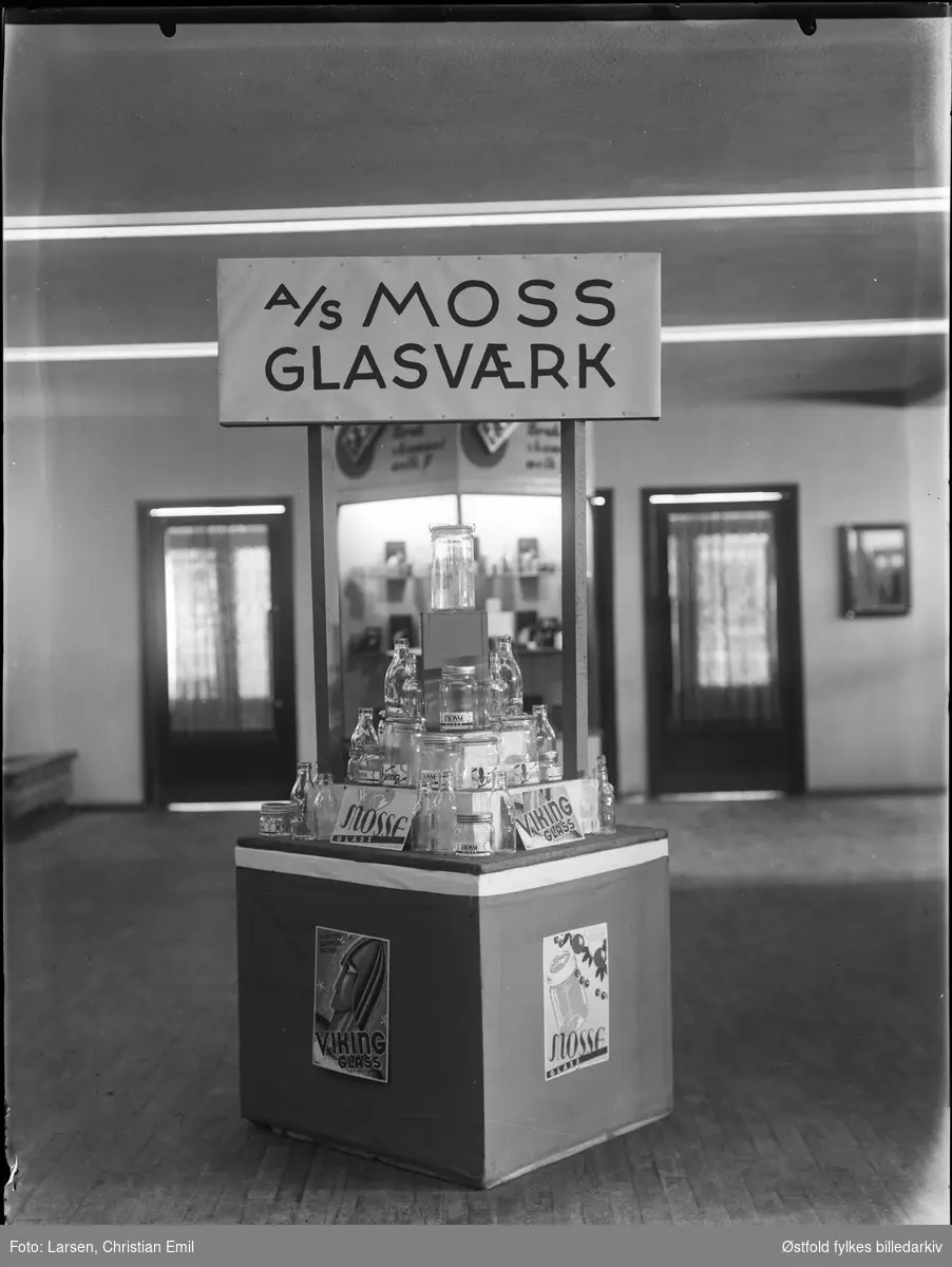 Utstillingsmonter, Moss Glassverk A/S, lapp på monter Viking Glass. Stilt ut forskjellige flasker og Norgesglass.