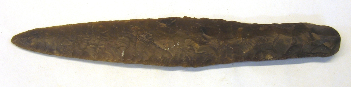 10 279: Boberg, Årstad härad, Halland.

Dolk, 1st av ljusbrun flinta. 4- sidigt skaft. Parallellhugget blad. L. 26,9 cm, br. 4,6 cm.