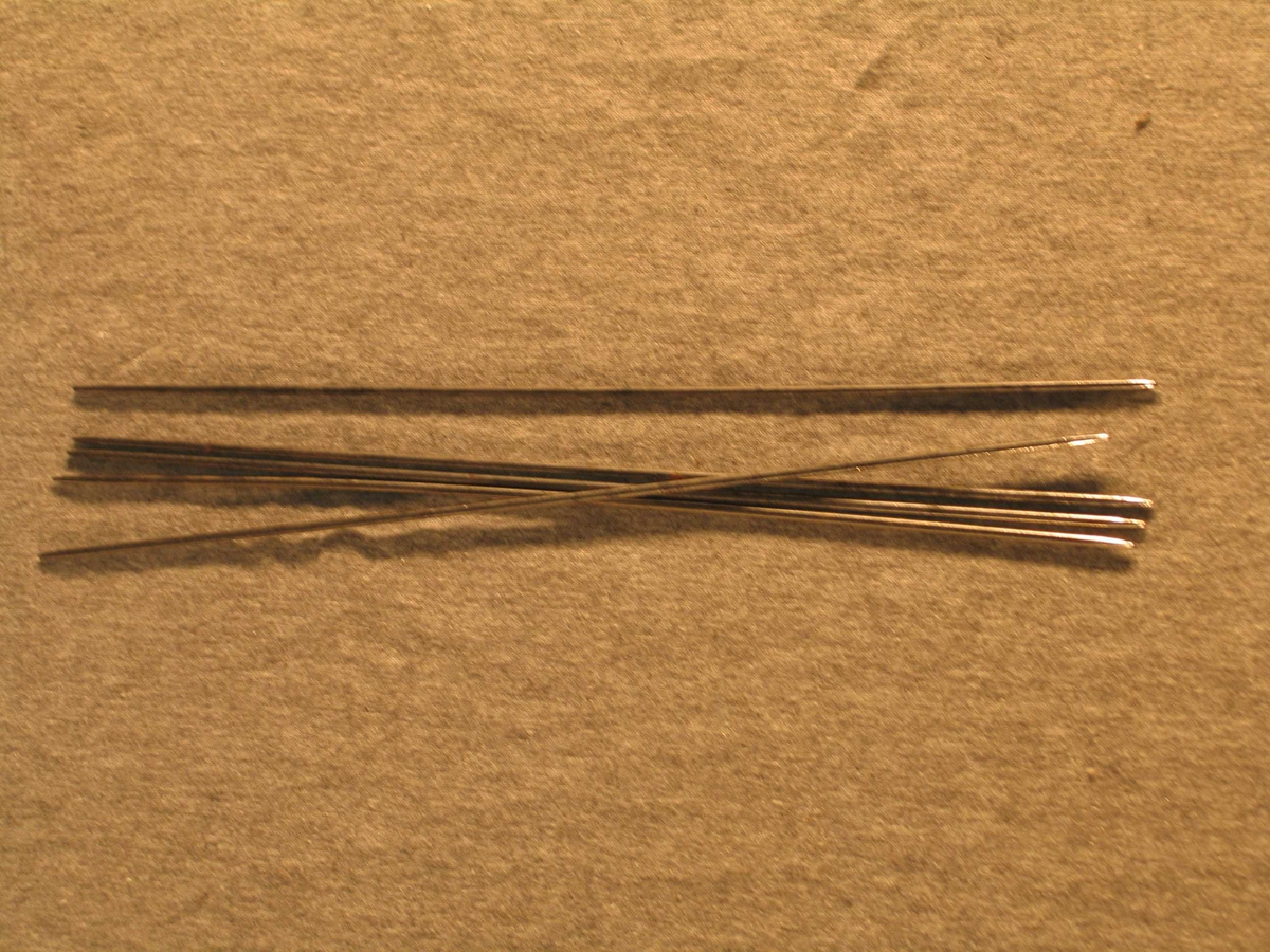 5 strikkepinnar som utgjer eit sett strømpepinnar. 
