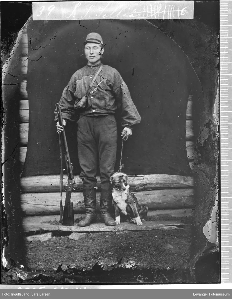 Portrett av mann med våpen og hund.