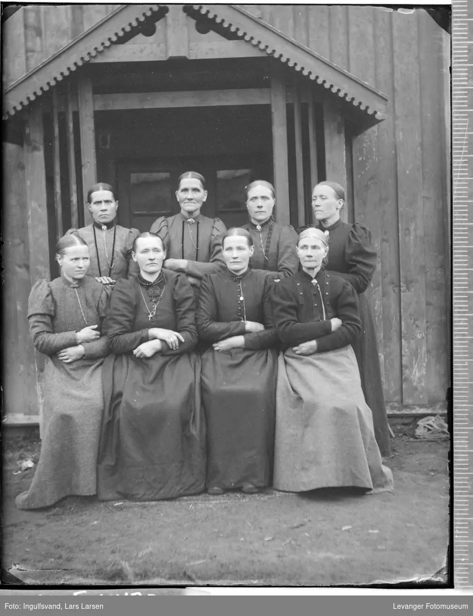 Gruppebilde av åtte kvinner foran et inngangsparti.