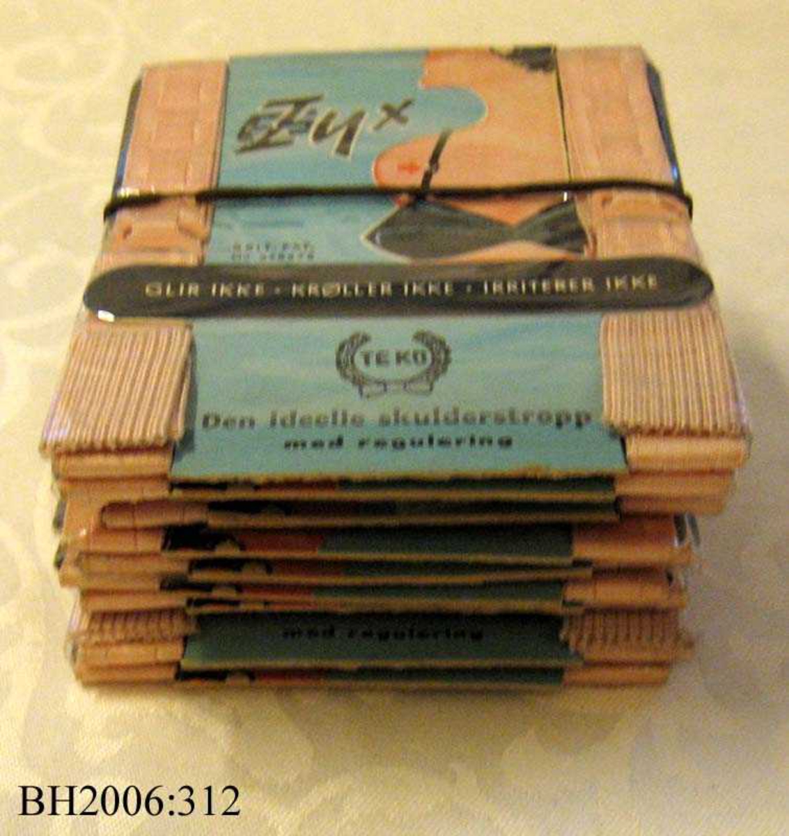 11 pakker med BH-stropper buntet sammen med en strikk. Hver og en er pakket inn i plast.