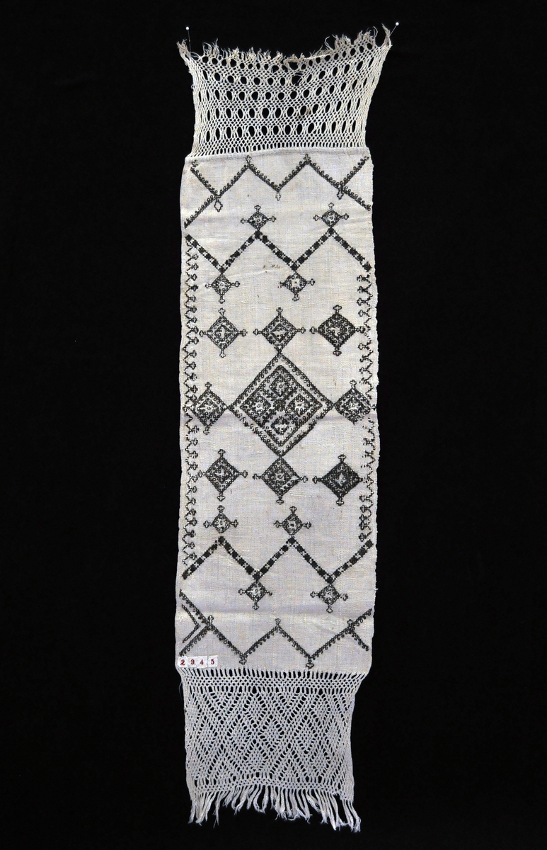 Fra protokollen:
Hjemmearbeidet lin med haandklædefletning og uldsøm.