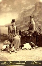 To kvinner m hunder sittende i fotoatelier med fjordbakgrunn