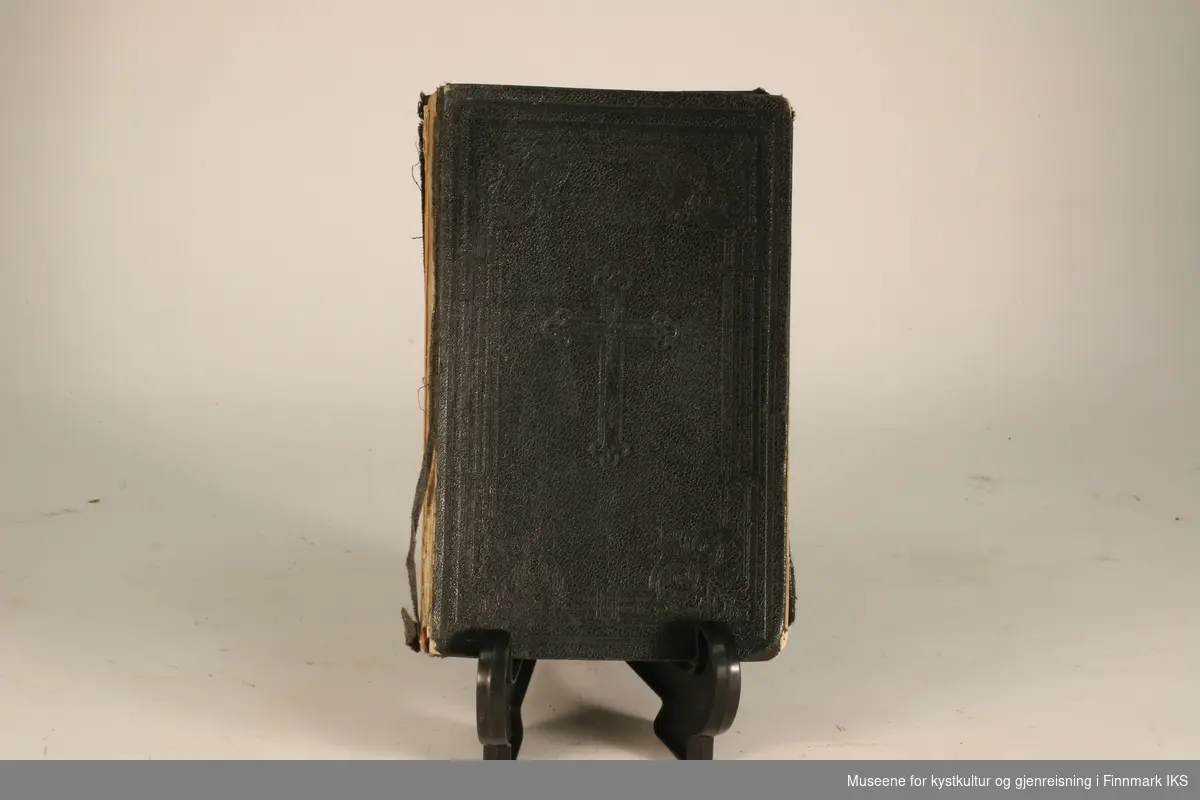 Salmebok fra slutten av 1800-tallet. Permene er trukket med sort stoff og har et kors trykket i seg.