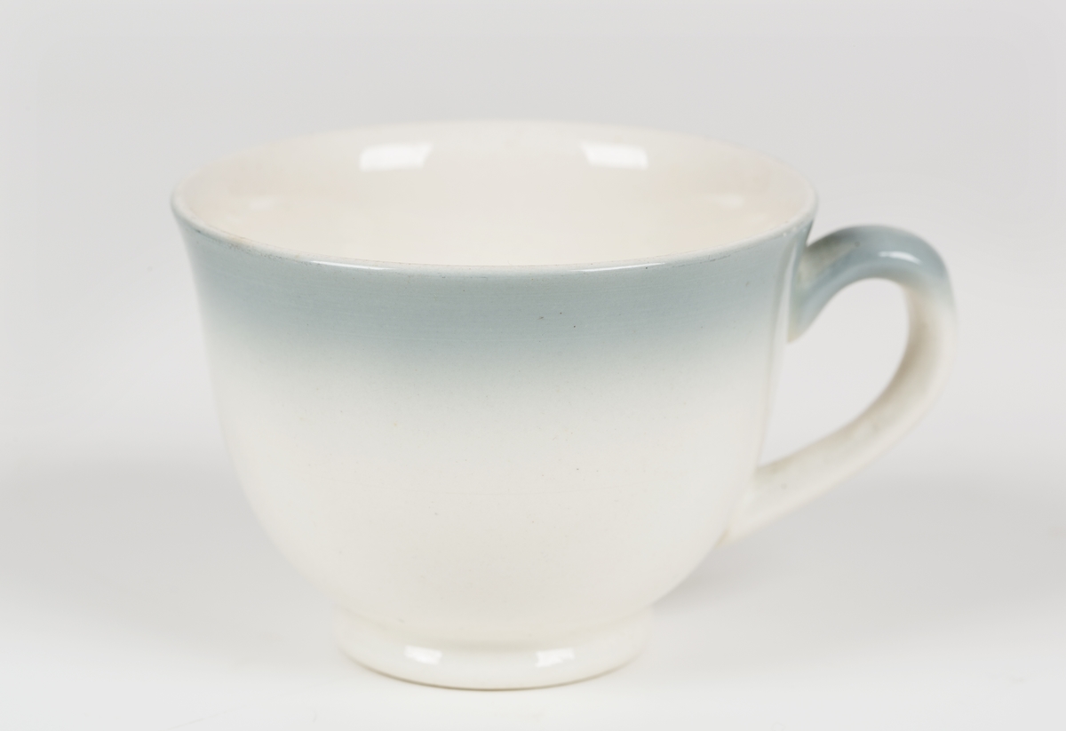 Hvit kopp med lys blå kant.
