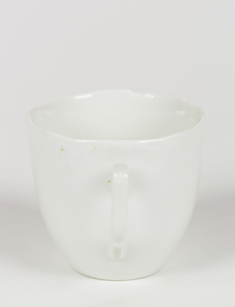 Hvit kopp med dekor.