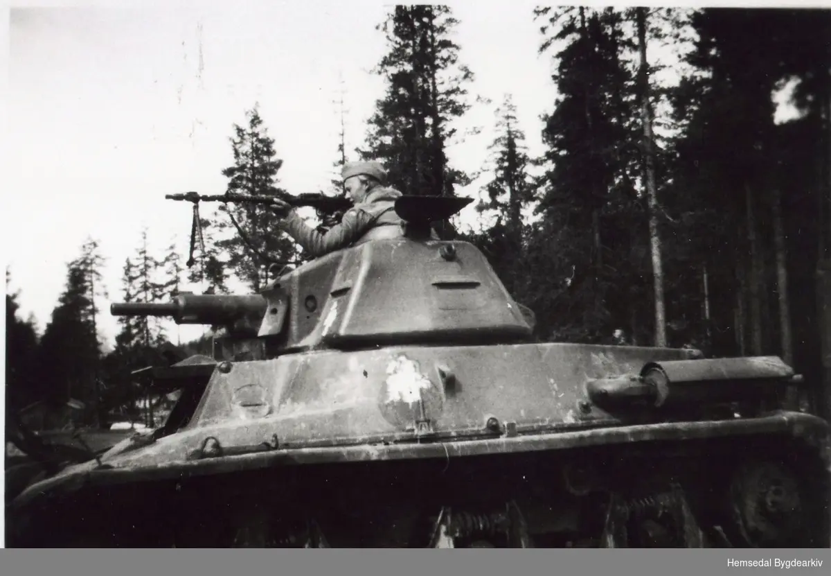 Frå innspelinga av filmen "Krigsår i Hallingdal". Ole Svingen var med på innspelinga. Her oppå ein tanks, Hotchkiss.