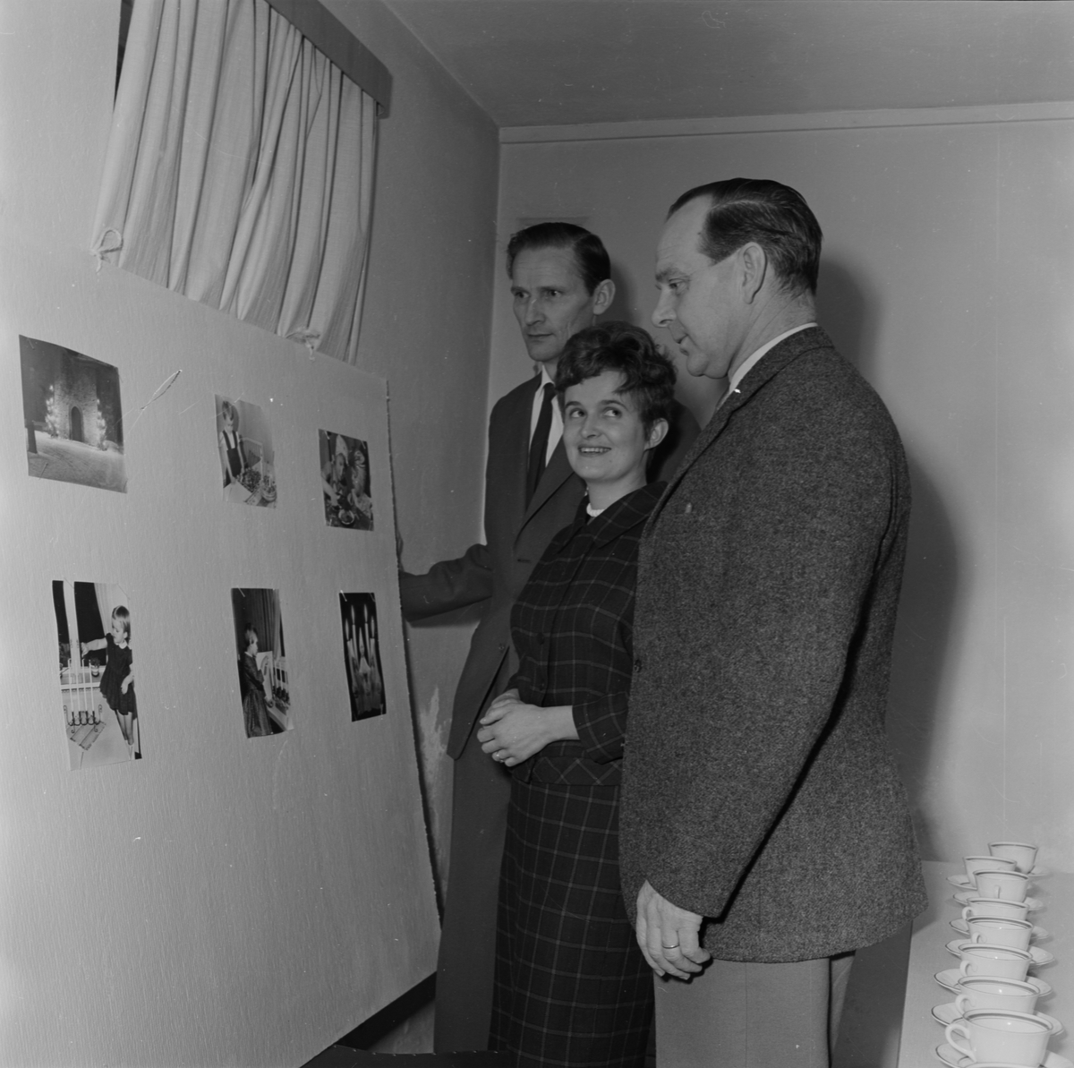 Män och kvinna tittar på fotografier, Uppland 1962