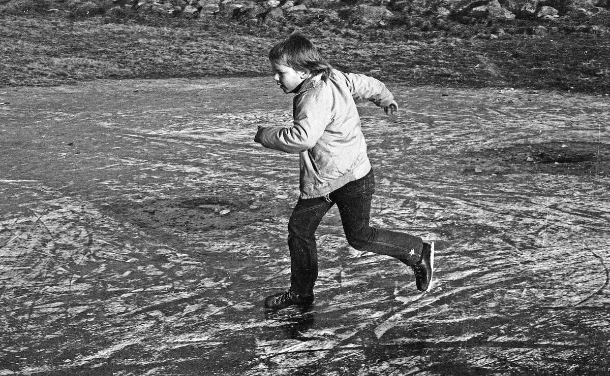 Barn på isen. Islagt vann på Norheim. Flere barn går på skøyter. Kaldt vintervær.