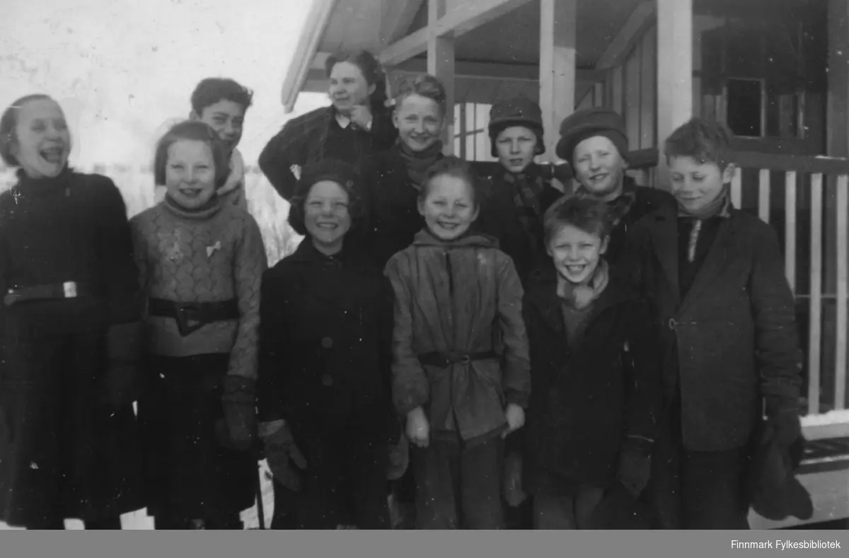 Under annen verdenskrig hadde tyskerne rekvirert Neiden skoleinternat, og skolen hadde lokaler i Neiden fjellstue 1941-1943. Her ser vi en flokk blide unger fotografert utenfor fjellstua