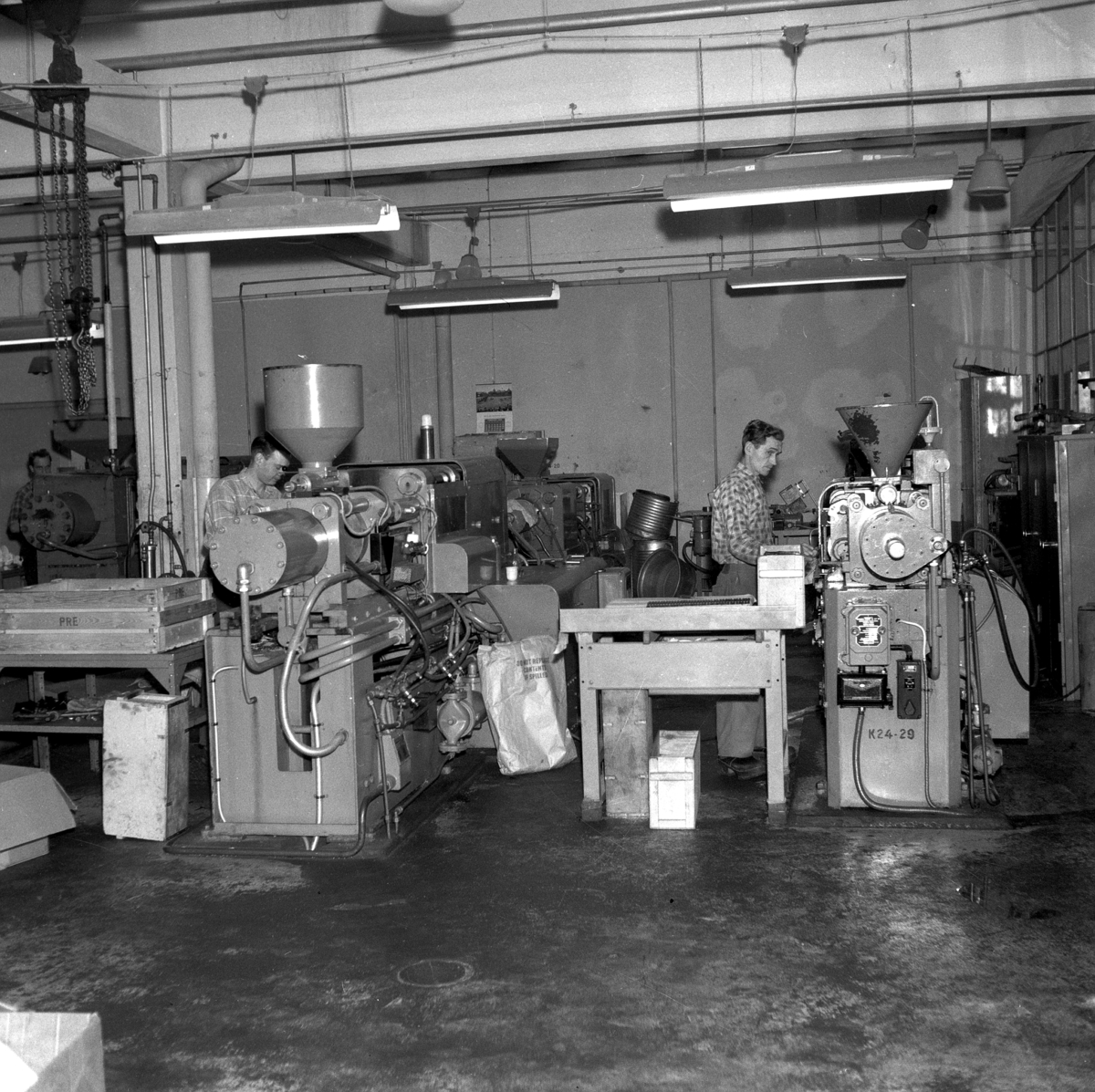 Några män som arbetar vid maskinerna på Huskvarna Borstfabrik.